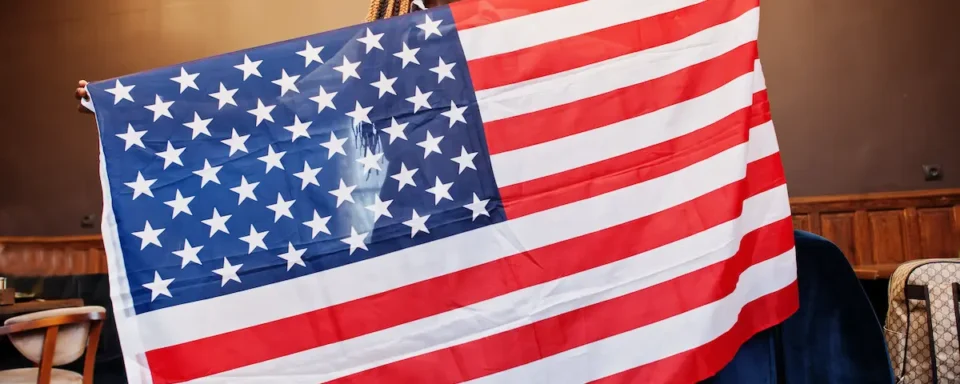 An African American woman proudly holds the American flag for Juneteenth.