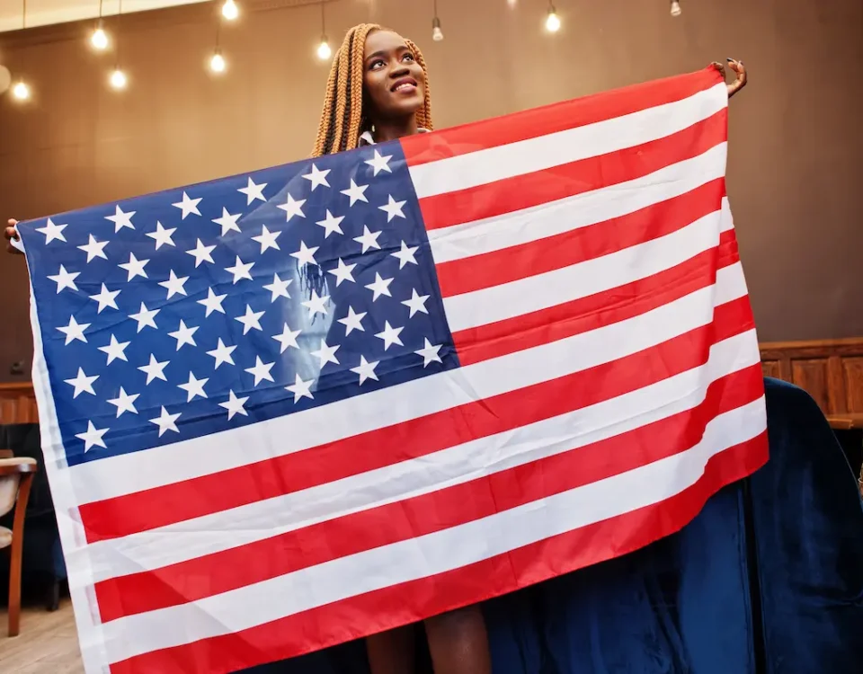 An African American woman proudly holds the American flag for Juneteenth.
