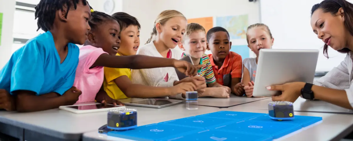 Preschool children learning in school with gadgets. 