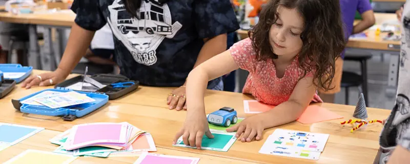 Preschool girl learning coding with Sphero indi.