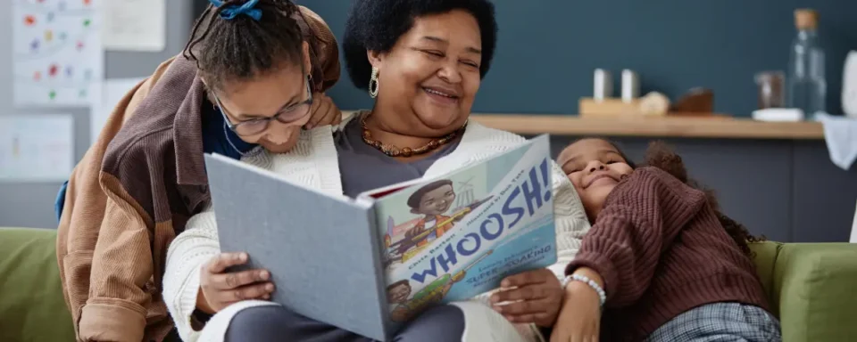 Woman reading the book, Whoosh, by Lonnie Johnson to her kids.
