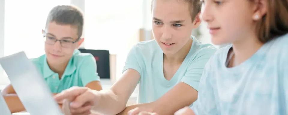 Kids crowd around a laptop, watching a modern STEM video on social media.