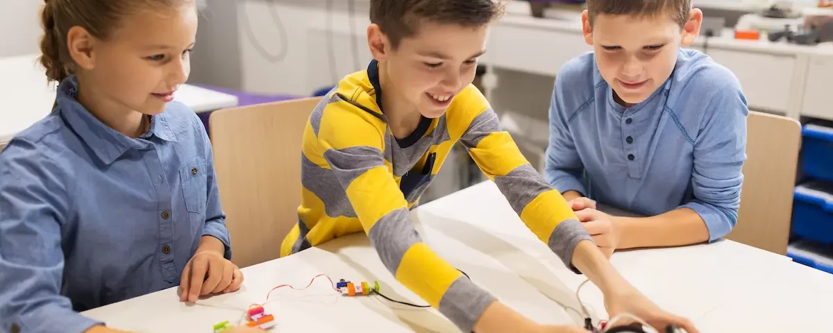 Three students at a table take part in project-based learning at school.