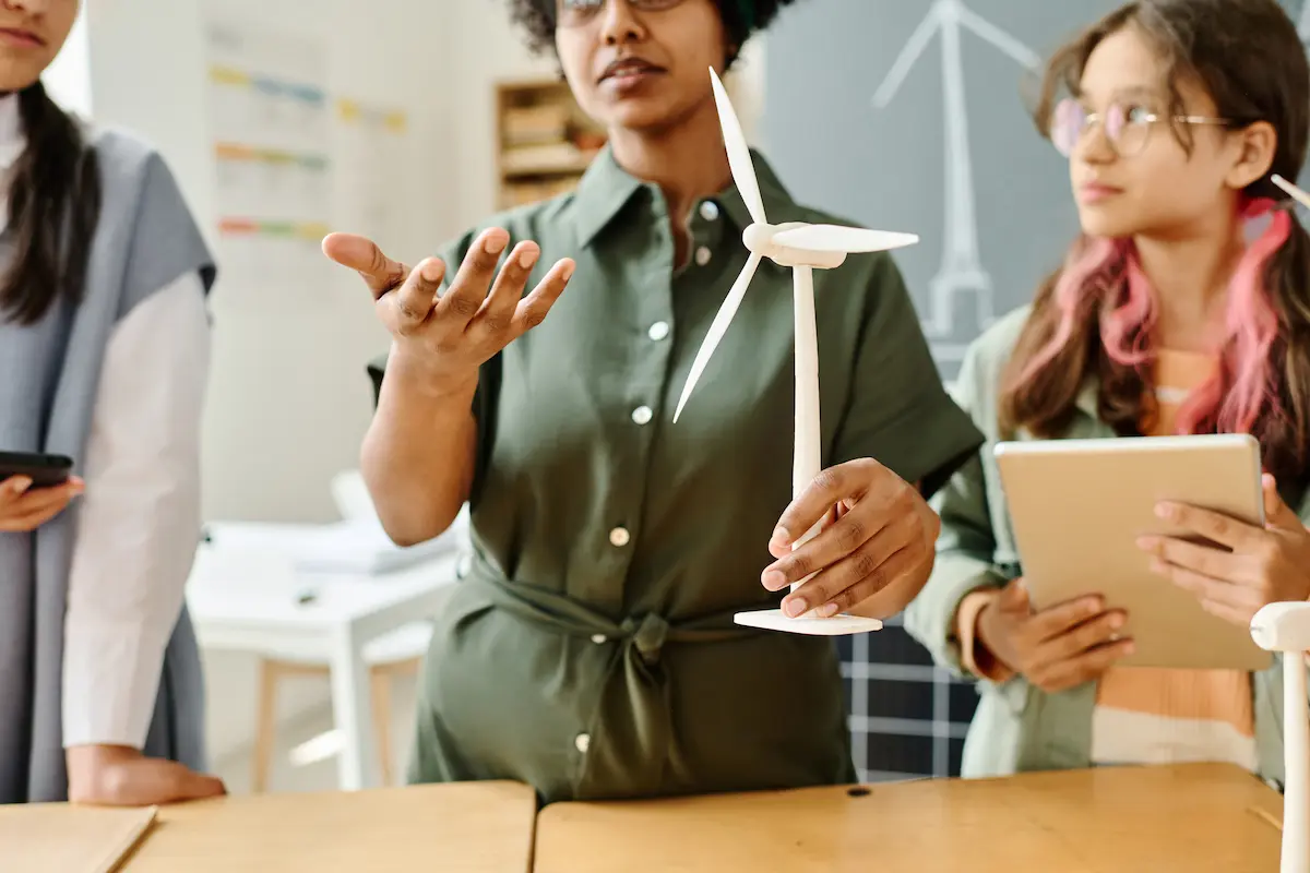 A teacher holds a windmill kit as she explains the project-based learning session to her class. 