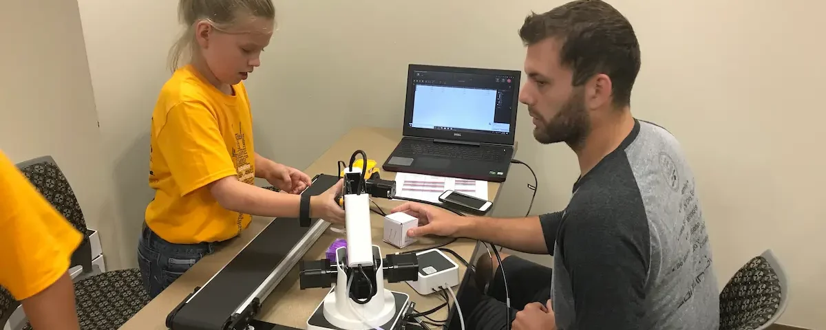 A young girl tinkers at a robotics summer camp