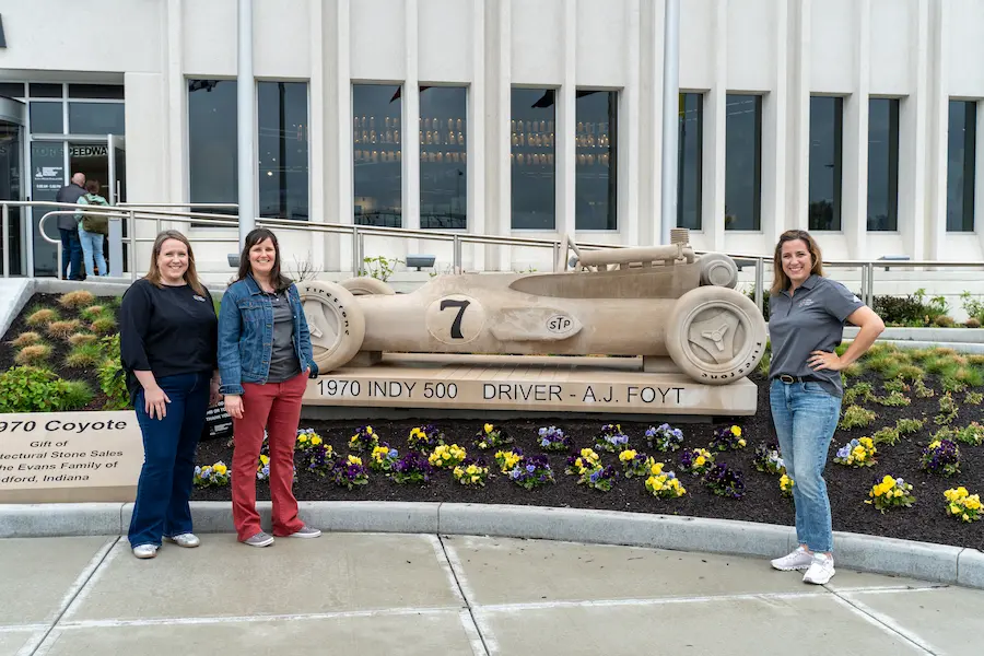 STEM Education Works team members with a statue of A.J. Foyt's 1970 Indy Car