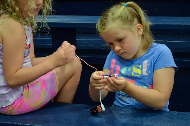 Little girl concentrates during a STEM summer camp