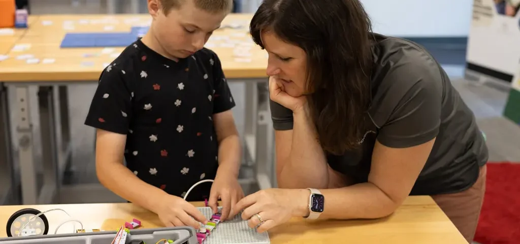 Educator assists student after installing a STEM lab