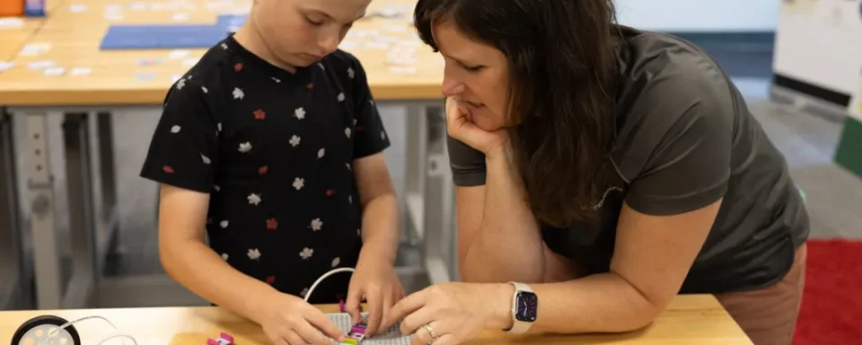 Educator assists student after installing a STEM lab