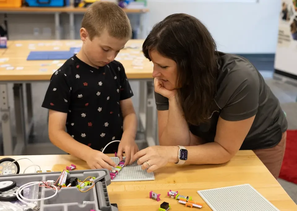 Educator assists student after installing a STEM lab