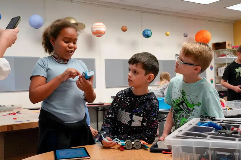 Three young techies work together to problem solve.