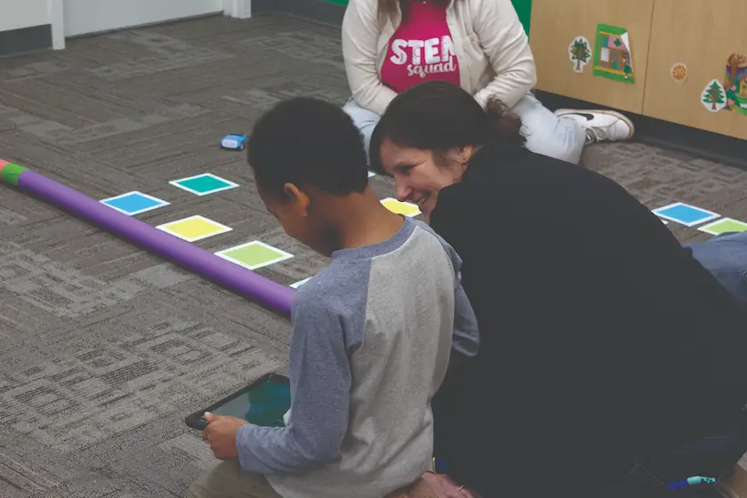 A STEM Education Works team member assisting a student