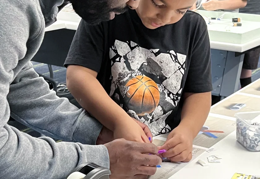 A father and son work together on circuitry