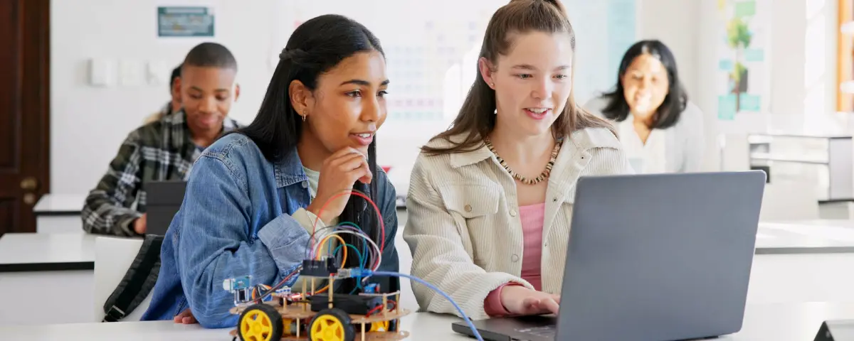 Two teenagers using AI in the classroom.