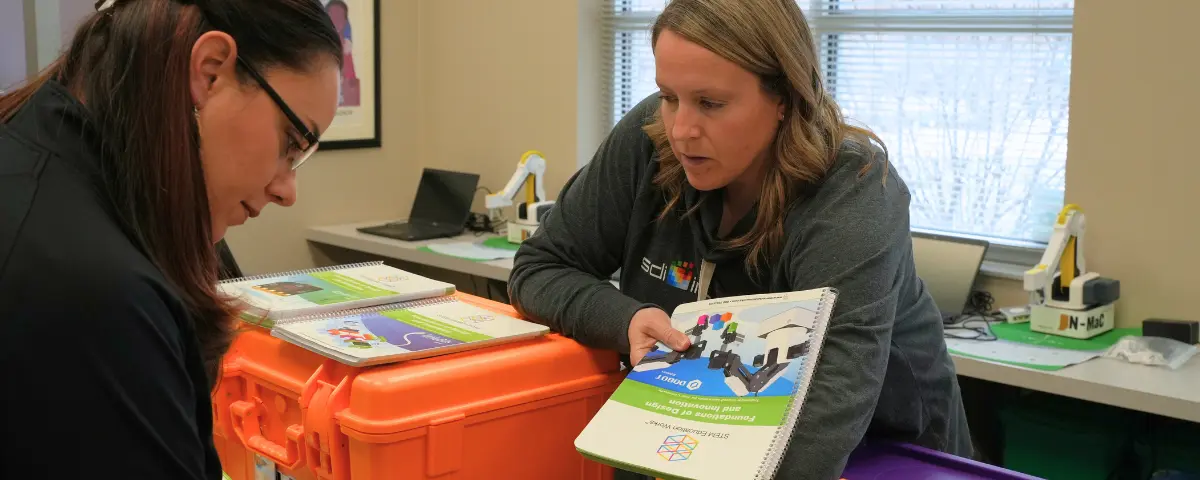 A teacher holding a copy of STEM Education Works’ Foundation of Design and Innovation curriculum book. 