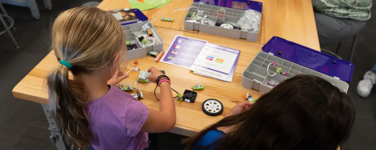 Two students working on littleBits using STEM Quest Activity Cards. 
