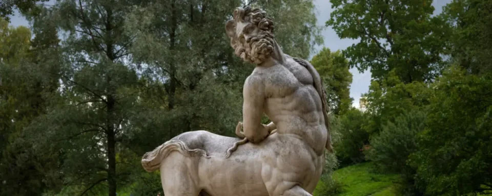 Marble statue of a male centaur leaning backwards.