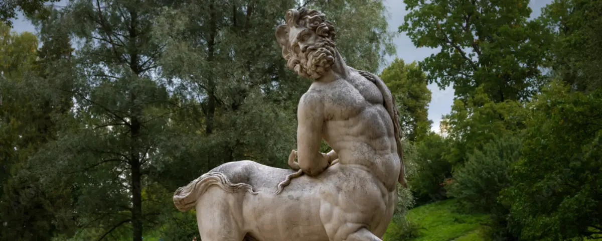 Marble statue of a male centaur leaning backwards.