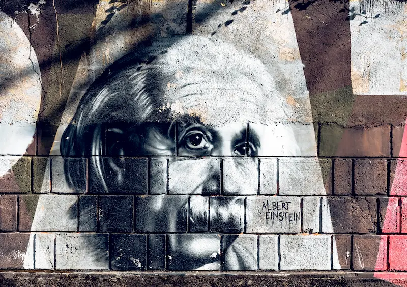 Mural of Albert Einstein on a brick wall.