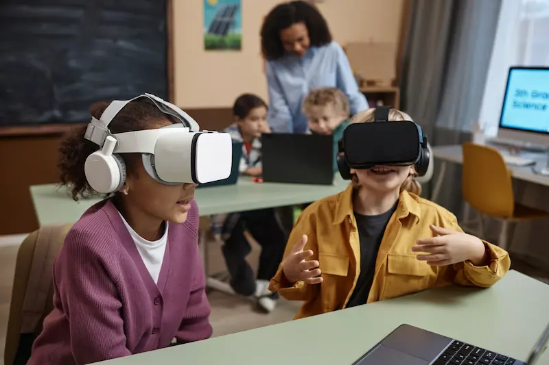 Several children using virtual reality headsets in a bright classroom.
