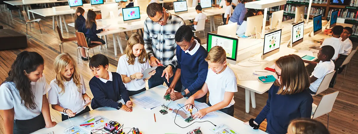 A group of students working on a STEM project on a table in a library.