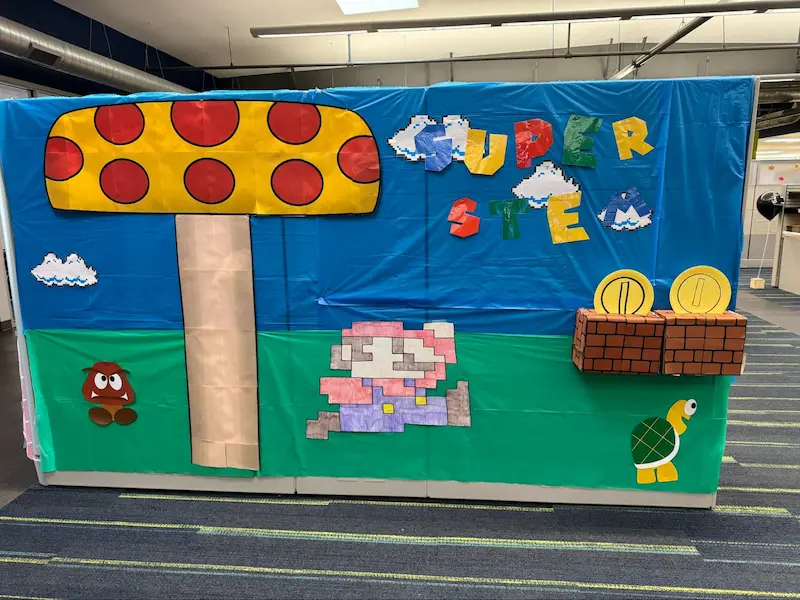Mario Bros. themed decor with a mushroom, pixelated Mario, and “Super STEM” title.