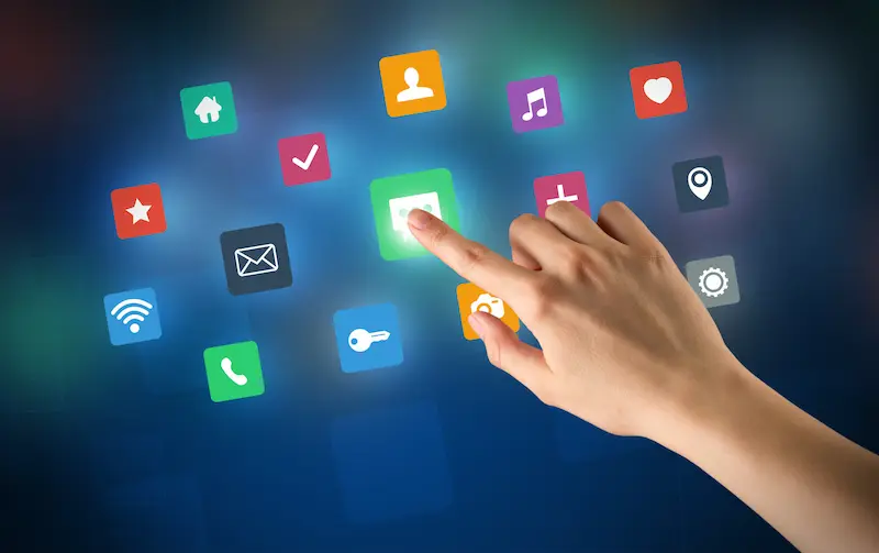Finger tapping app icons on a digital screen.