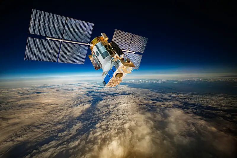 A satellite orbiting above Earth in space.