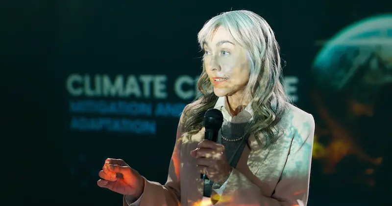  A woman giving a presentation on climate change to an auditorium.