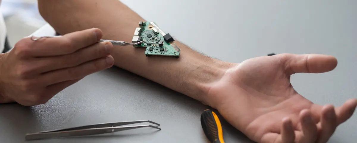 Man repairing a computer chip on his arm.