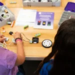 Two girls building a small robot car.