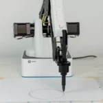 Dobot Magician drawing a circle on a piece of paper using the pen end effector.
